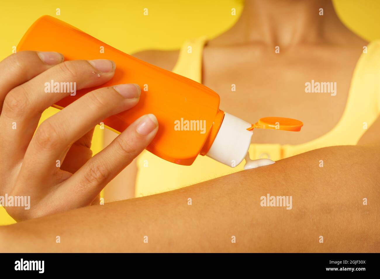 la ragazza si protegge con il sunscream dai raggi uv del sole Foto Stock