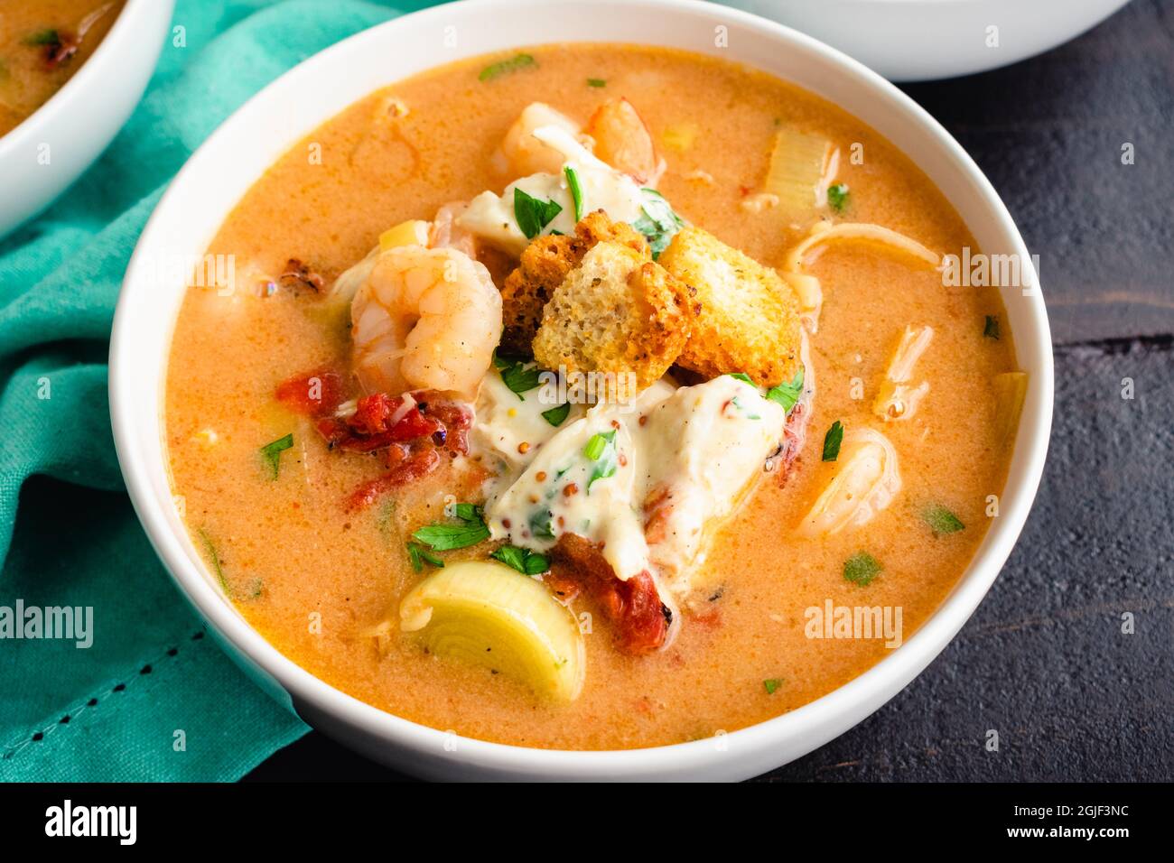 Ciotole di gamberi e granchio con contorno: Pesce bisque condito con insalata di granchio, crostini e prezzemolo Foto Stock