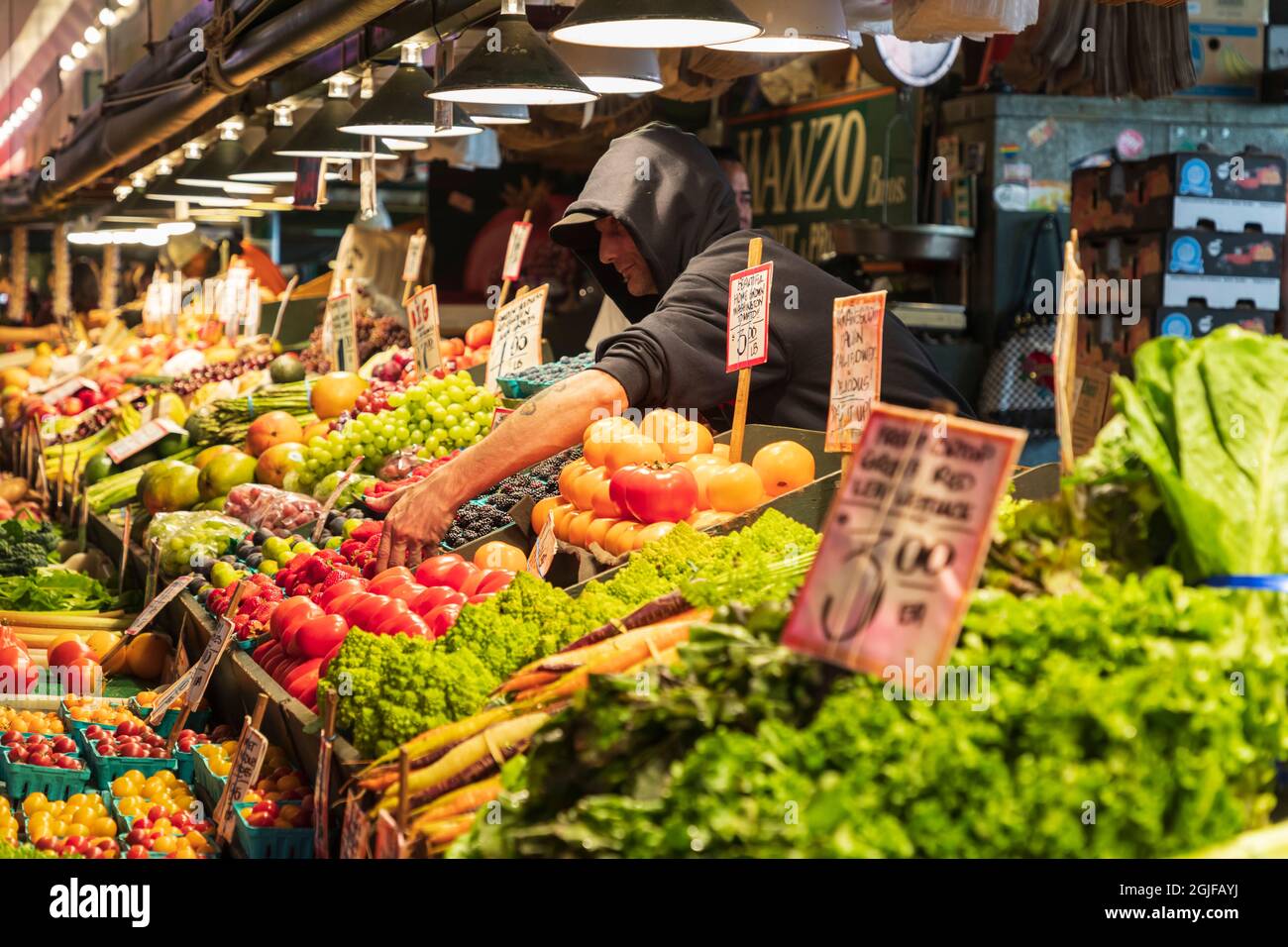 USA, Washington state, Seattle, Pike Place Market. Venditore che vende prodotti freschi. (Solo per uso editoriale) Foto Stock