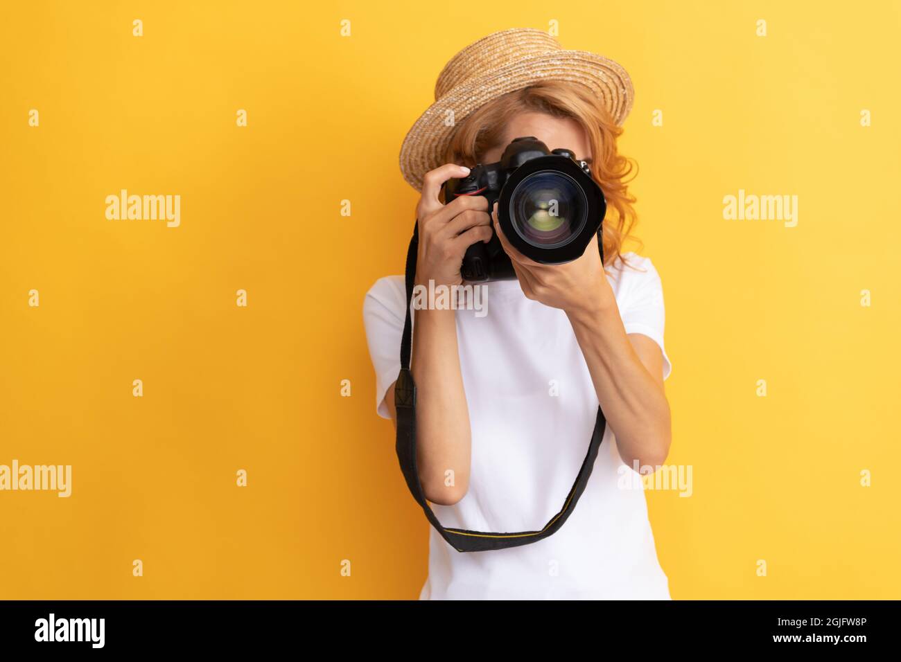 fotografo da viaggio donna con macchina fotografica in cappello di paglia che fa foto, messa a fuoco Foto Stock