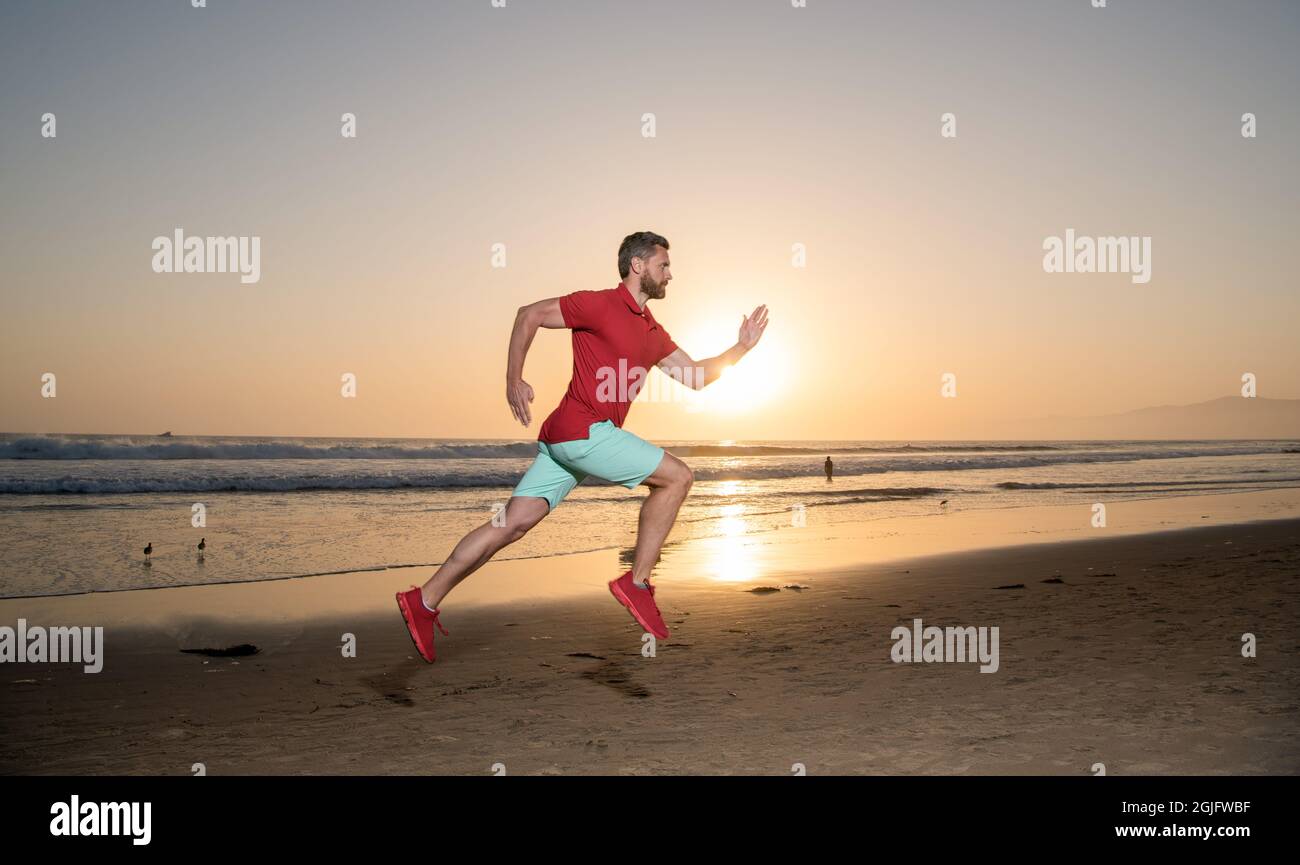 sprinter sportivo che corre sulla spiaggia estiva alba all'oceano, jogging Foto Stock