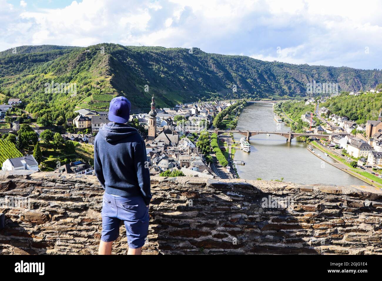 Un giovane uomo che si affaccia sulla città di Cochem dal castello imperiale. Foto Stock