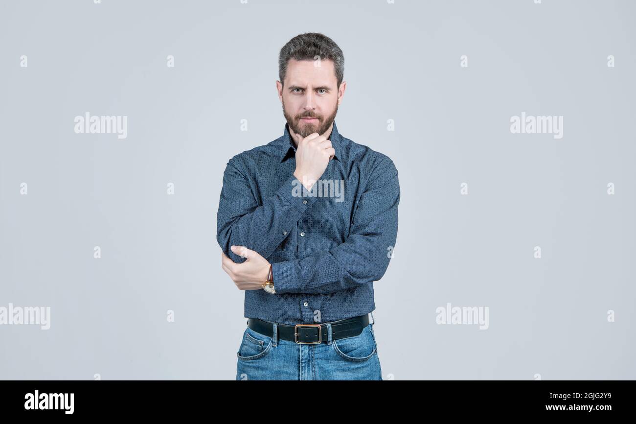 Abbigliamento per l'uomo serio. L'uomo bearded pensa sfondo grigio. Aspetto serio. Mento proppante Foto Stock