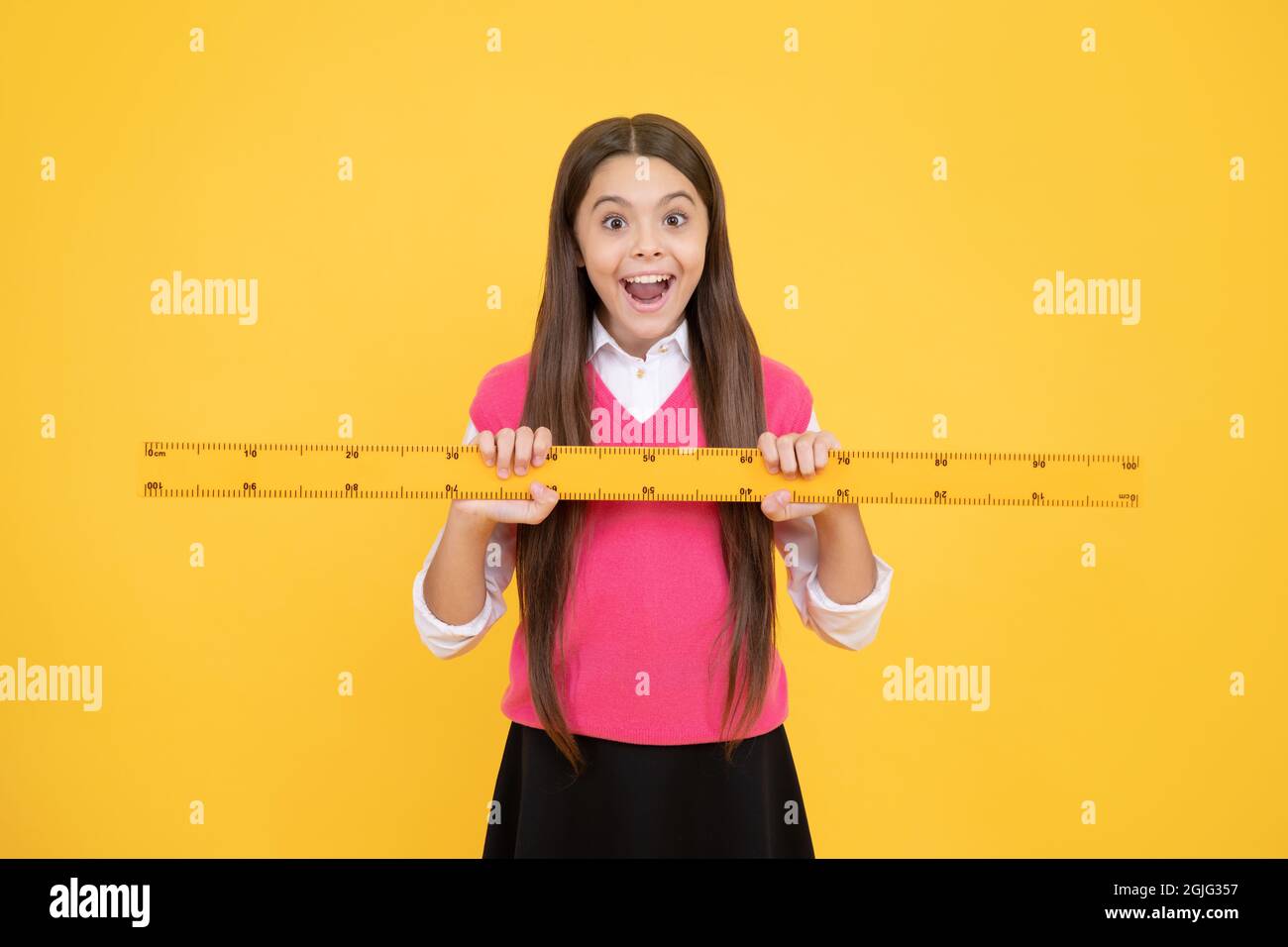 sorprendo ragazza capretto utilizzare righello per imparare matematica, misurazione Foto Stock