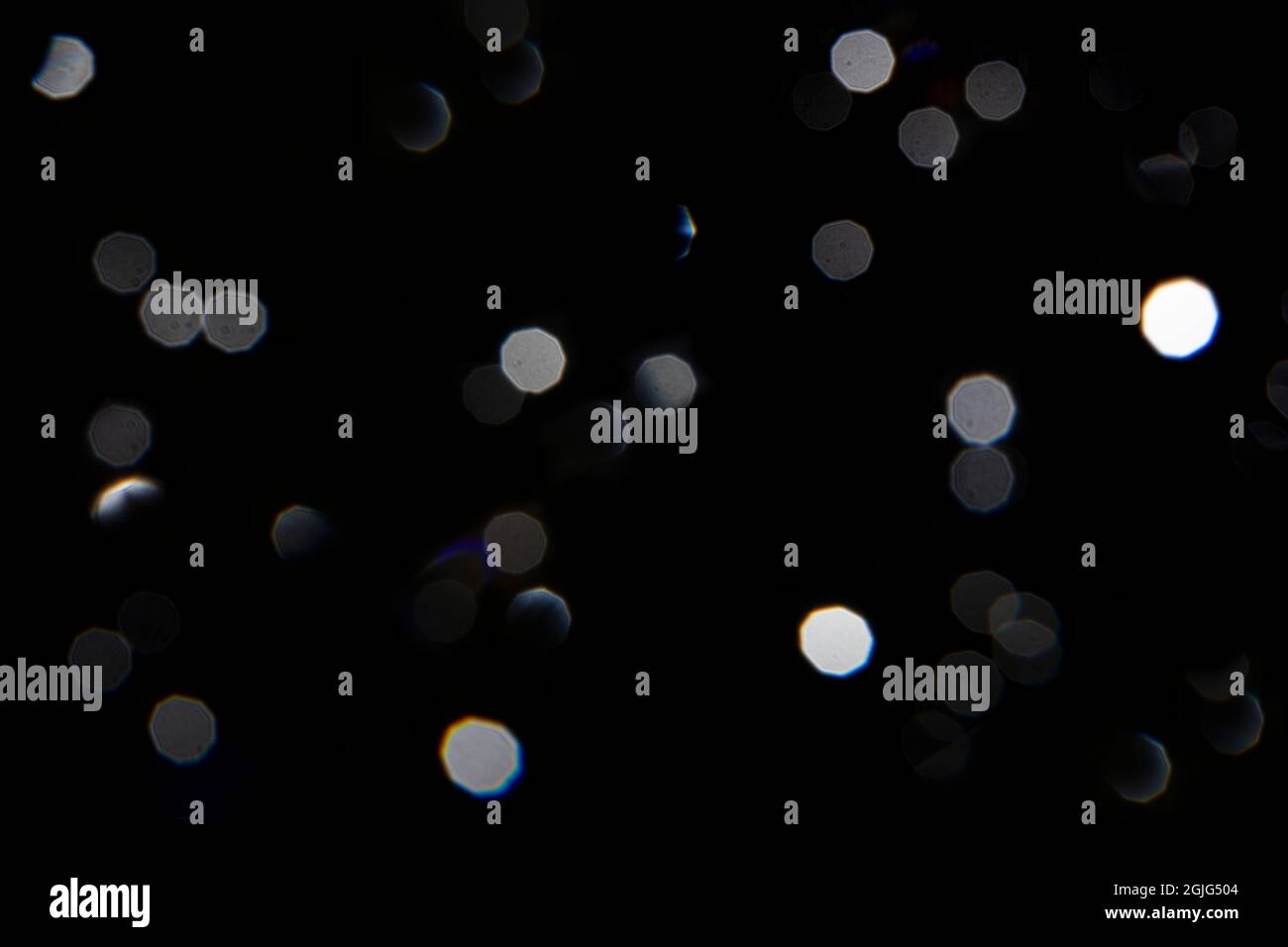 Gocce d'acqua sull'obiettivo creando un bokeh sul nero Foto Stock