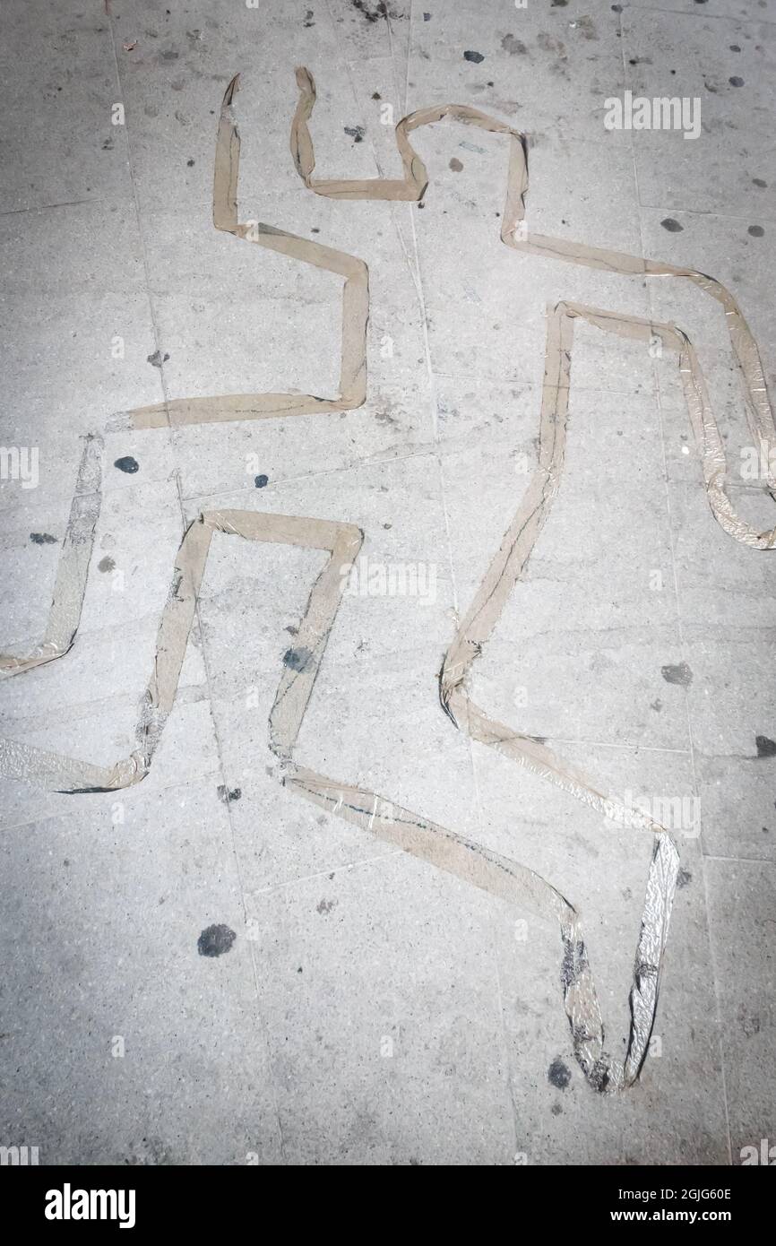 Silhouette del corpo morto sul terreno realizzata con nastro adesivo. Concetto di scena del crimine. Foto Stock
