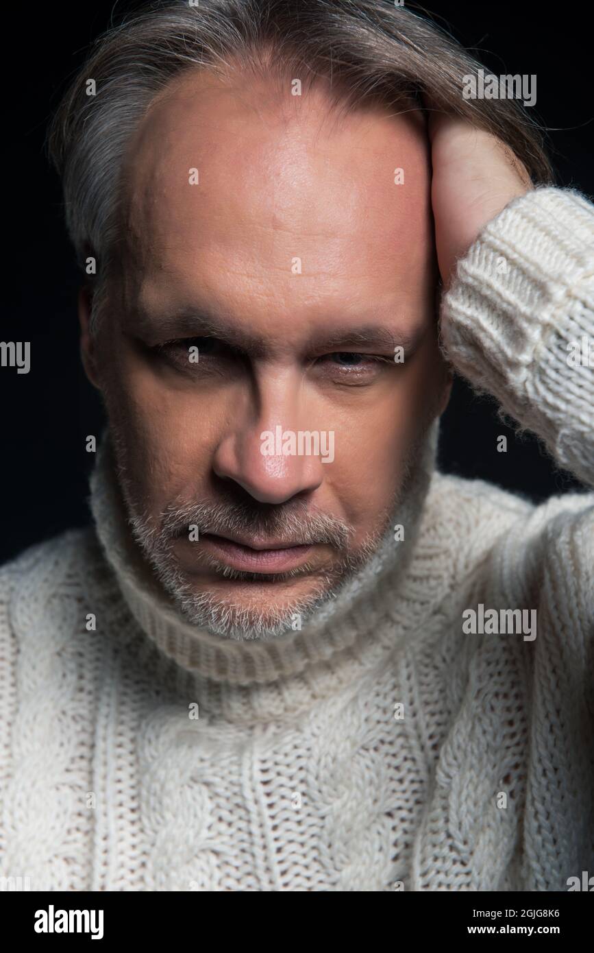 Uomo maturo attraente con barba su sfondo semplice indossando casual Foto Stock