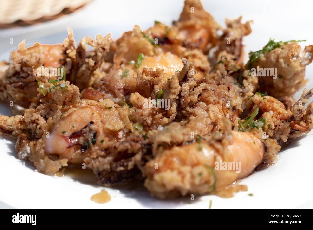 'Chipirones fritos' calamari fritti conditi con limone serviti su un piatto. Cucina spagnola. Foto Stock