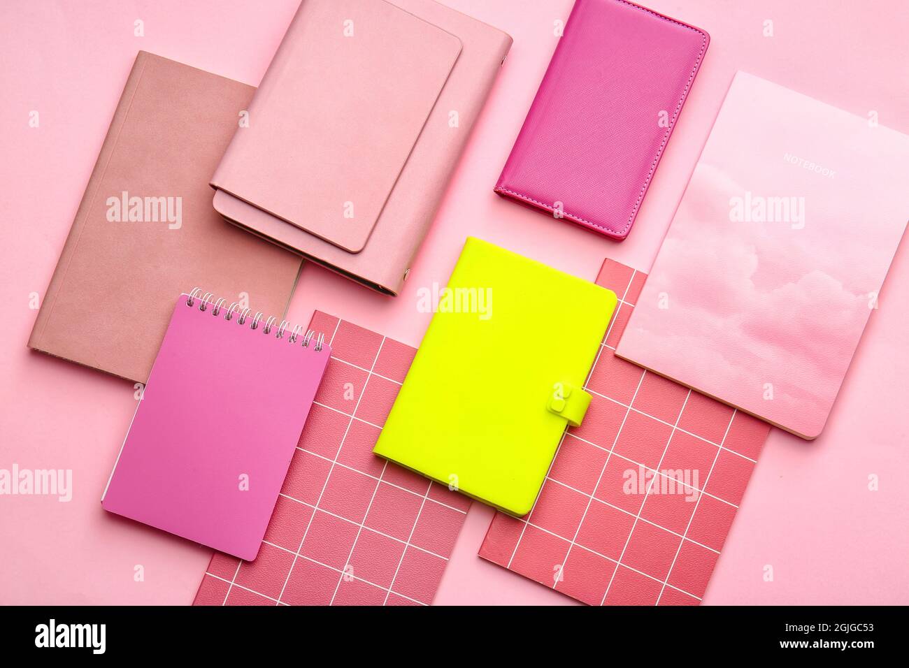 Notebook giallo tra quelli rosa su sfondo a colori. Concetto di unicità Foto Stock