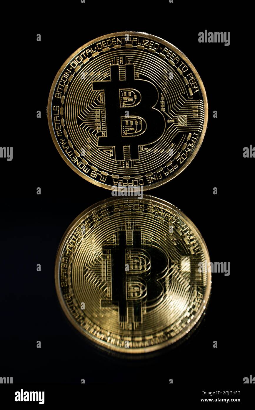 Bitcoin d'oro sulla parte superiore di uno specchio e sfondo nero Foto Stock