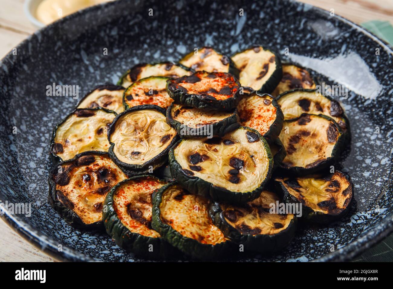 Piastra con gustose zucchine grigliate sulla tavola, primo piano Foto Stock