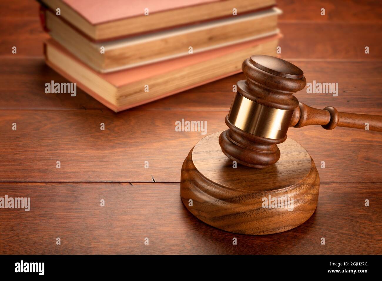 Un gavel si siede di fronte ad un libro di legge per dedurre la ricerca è necessaria per una difesa e per costruire un caso. Foto Stock