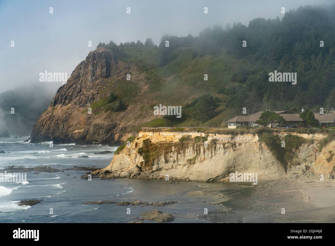 Le promontori resistono alle onde sulla costa dell'Oregon, USA. L'alto è costituito da basalto; quello inferiore presenta arenaria inclinata sotto una terrazza marina. Foto Stock