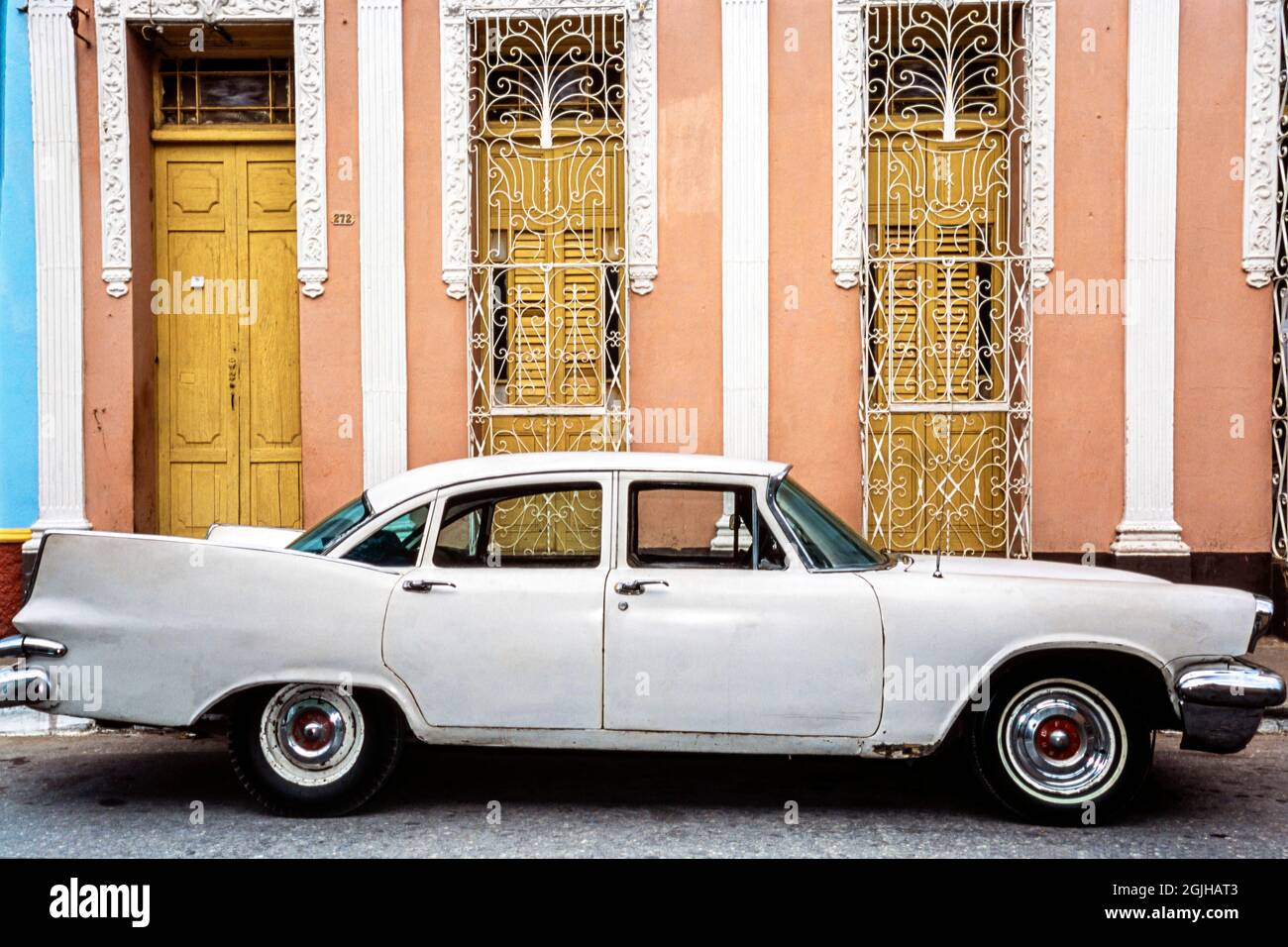 Auto americana classica anni '50 parcheggiata di fronte a casa con finestre e persiane, Sancti Spiritus, Cuba Foto Stock