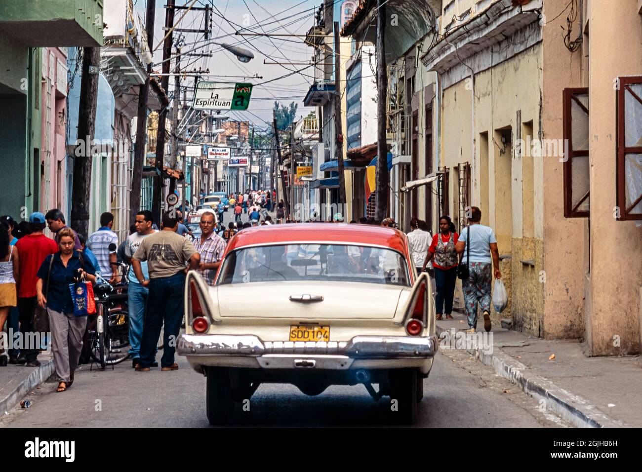 Auto americana classica con pinne che attraversano i pedoni nel centro della città, Sancti Spiritus, Cuba Foto Stock