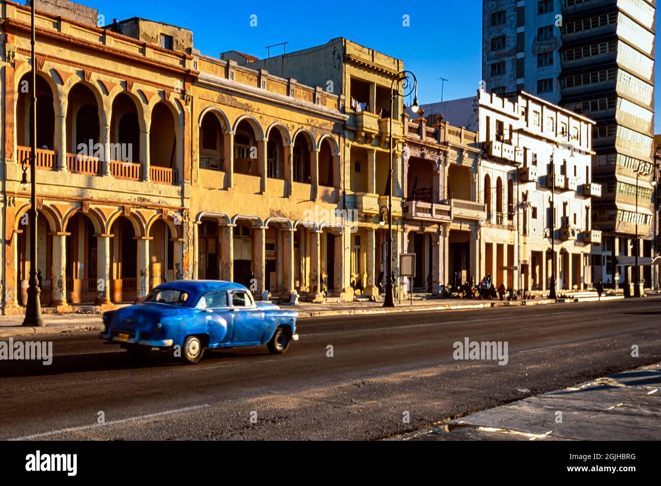 Vecchia auto americana classica che passa accanto a edifici in stile coloniale, l'Avana, Cuba Foto Stock