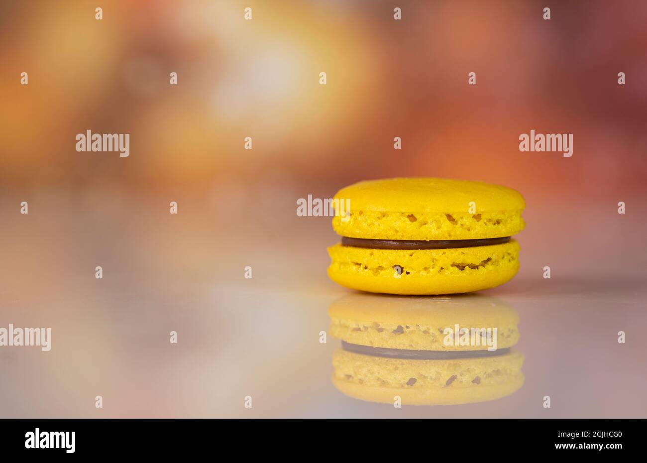 Single giallo deliziosi amaretti, un famoso dessert francese multicolore. Sfondo sfocato Foto Stock