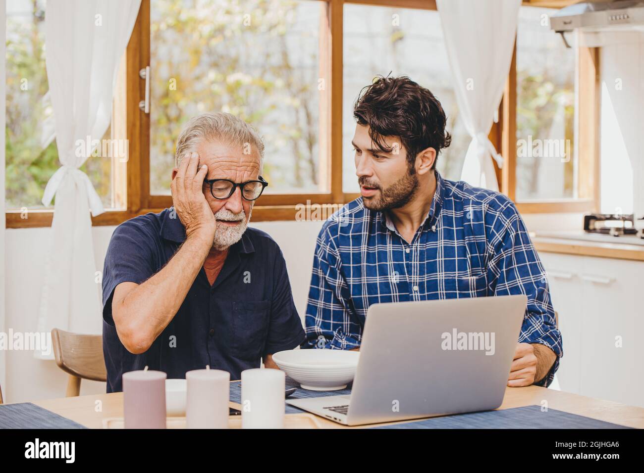 Anziano con Alzheimer e demenza perso account dimenticato username login password aiutare cura e consolazione da giovane figlio uomo. Foto Stock