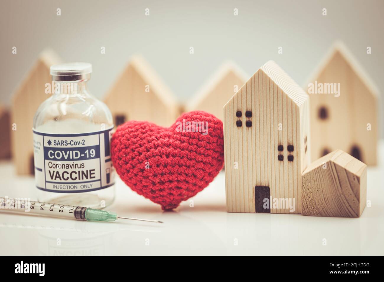 Immunità di gregge, modello domestico con cuore d'amore e la dose di vaccino di Covid per il bisogno sociale vaccinare per la prevenzione di Covid-19 insieme concetto Foto Stock