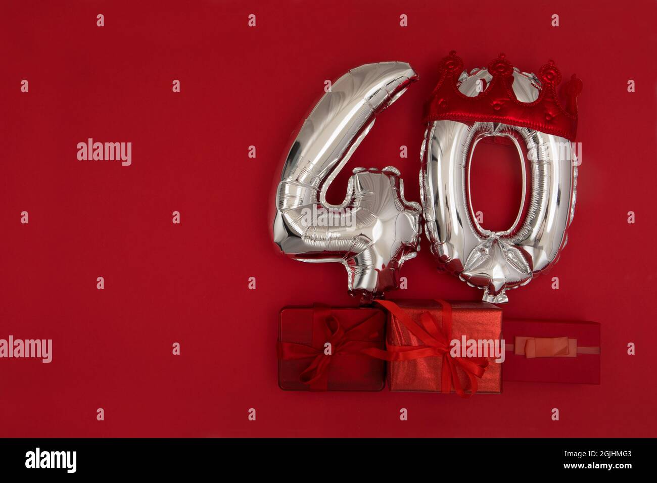 Palloncini argentati 40 quaranta in corona su sfondo rosso scuro. Decorazione festa di festa, 40 concetto di cartolina con vista dall'alto Foto Stock