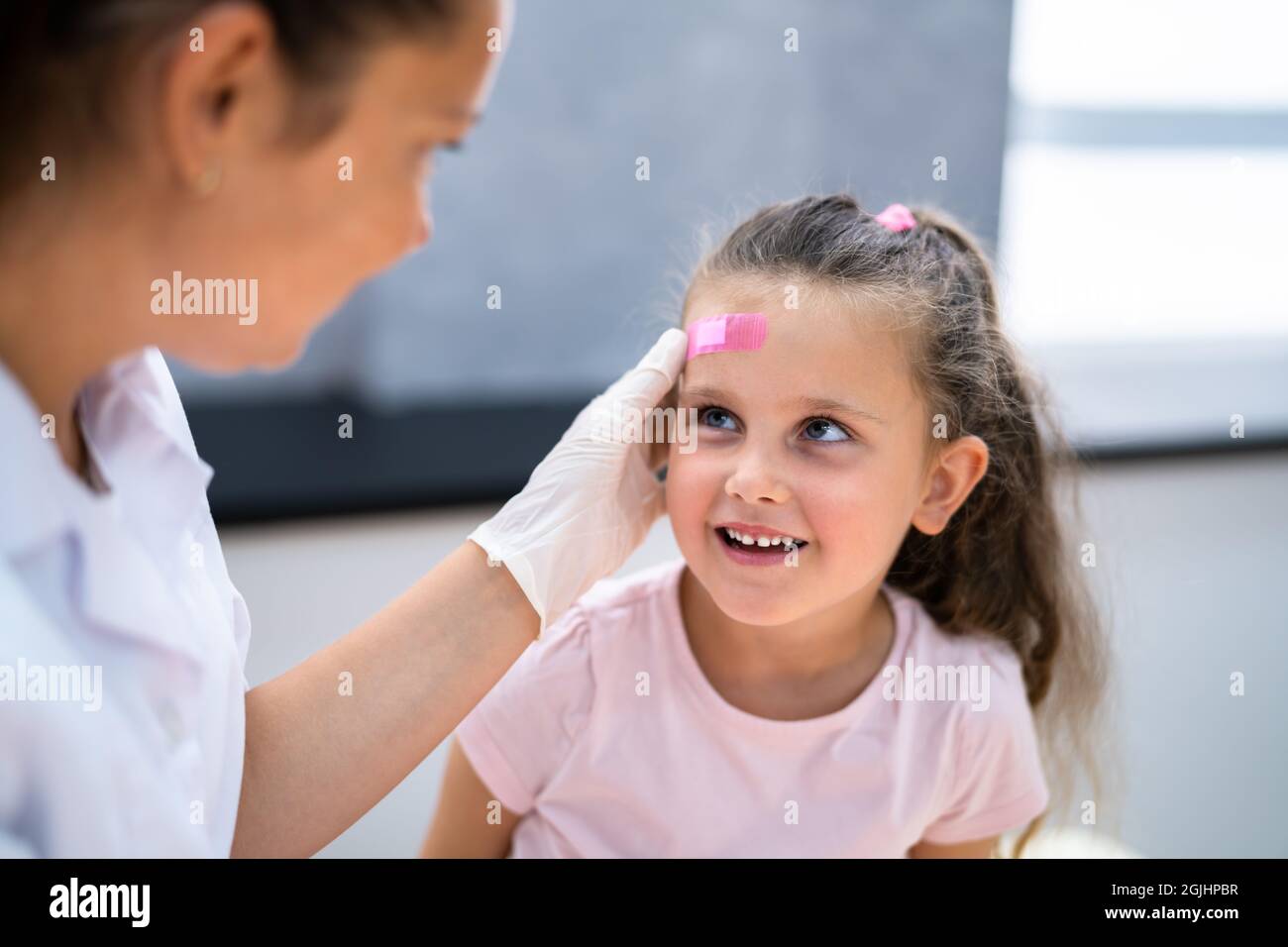 Applicazione di un ausilio per la fascia alla ferita dei bambini. Bendaggio per bambini Foto Stock