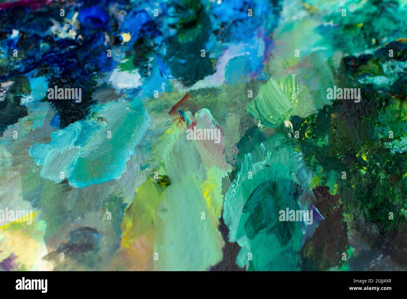 Primo piano della vernice a olio turchese blu. Sfondo multicolore sfocato. Le pitture professionali dell'artista sono a fuoco selettivo. Il concetto di creatività Foto Stock