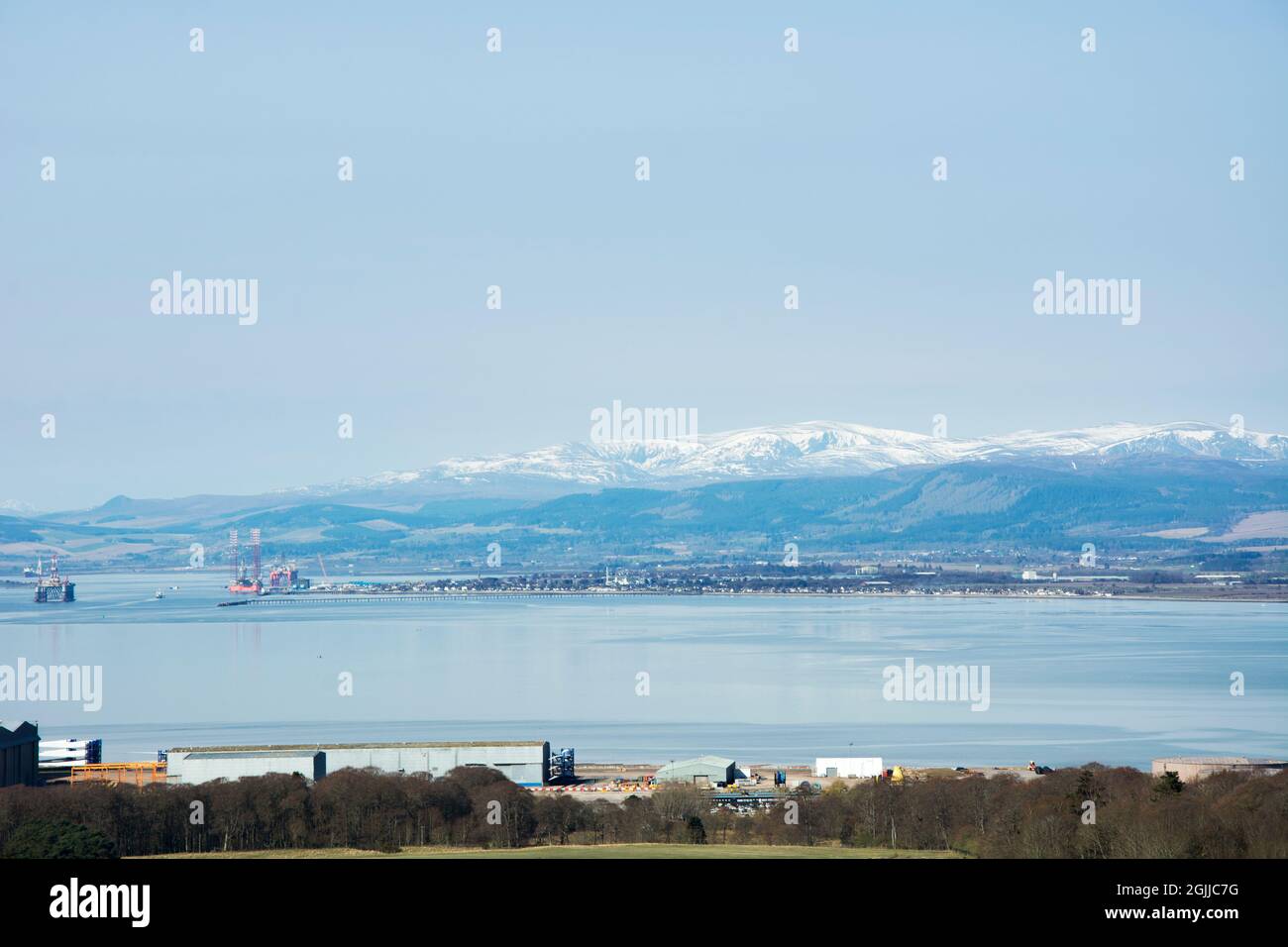 Imponenti torri ben Wyvis ricoperte di neve sopra la piccola cittadina di Invergordon, annidata al corto del Cromarty Firth interno nelle Highlands scozzesi Foto Stock