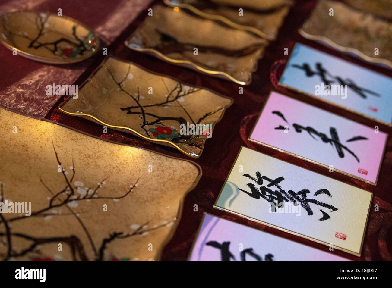 Piatti/vasi in ceramica giapponese tradizionali fatti a mano con decorazione e bordatura in oro e biglietti d'auguri con geroglifici calligrafici Foto Stock