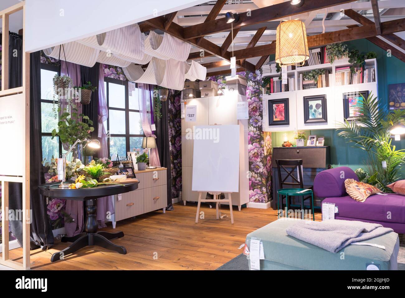 Camera con soffitto a travi in alto decorata con divano, sgabello per i piedi, unità di stoccaggio a parete e sponda laterale Foto Stock