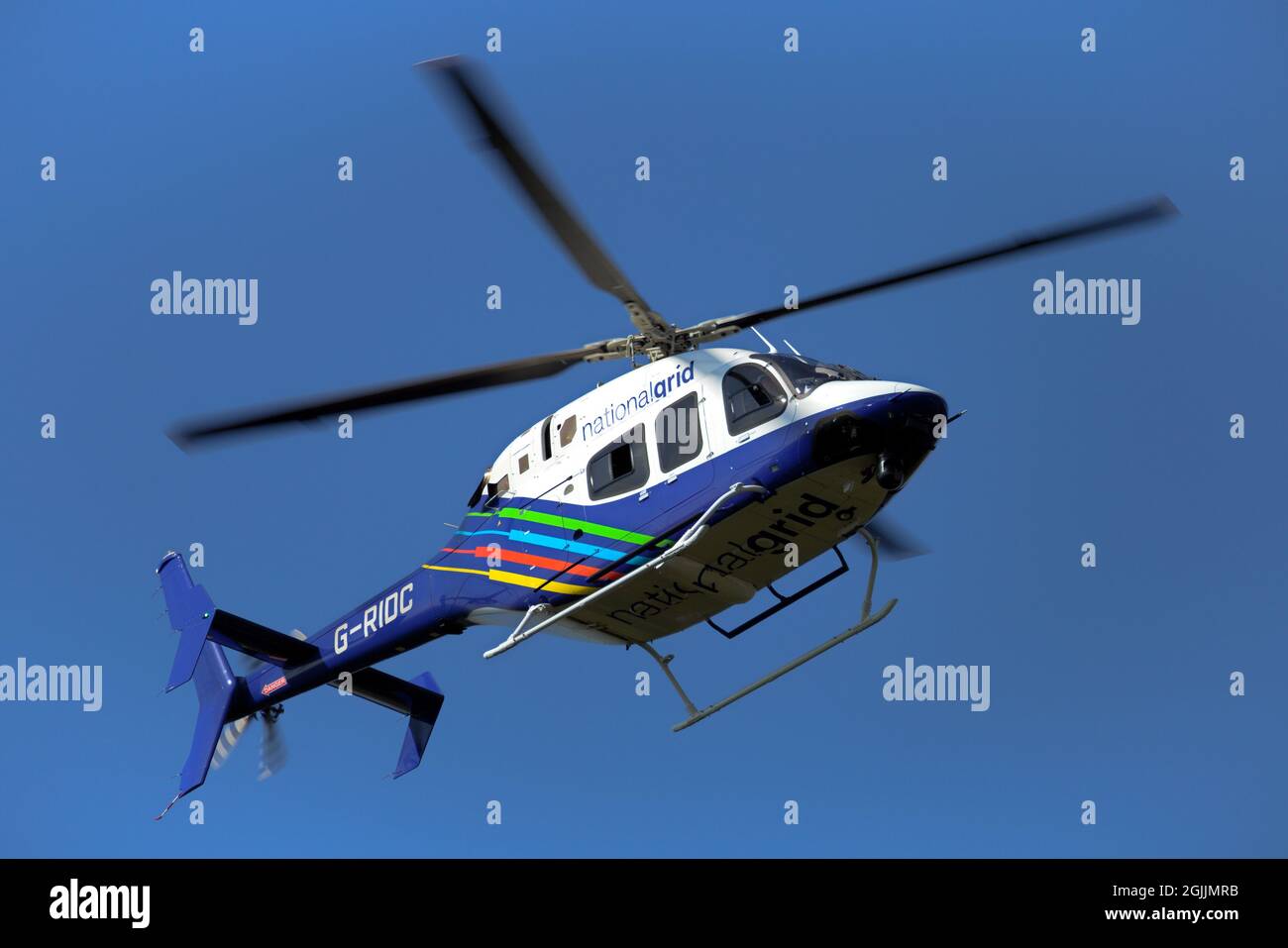 Un elicottero a griglia nazionale si aggira su un pilone mentre l'equipaggio effettua indagini sulle linee elettriche ad alta tensione sul North East Derbyshire. Foto Stock