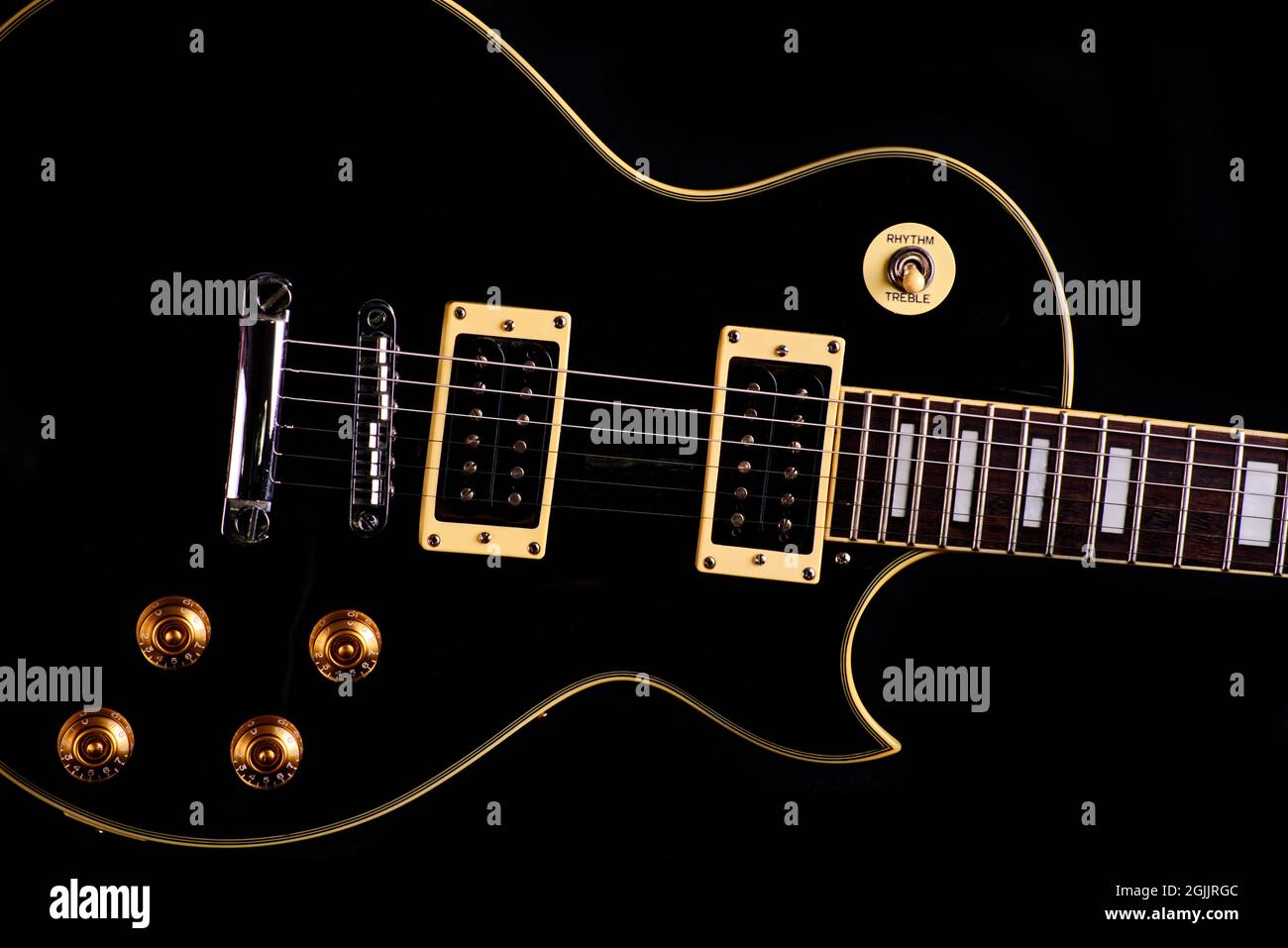 Primo piano di una chitarra elettrica nera su sfondo nero Foto Stock