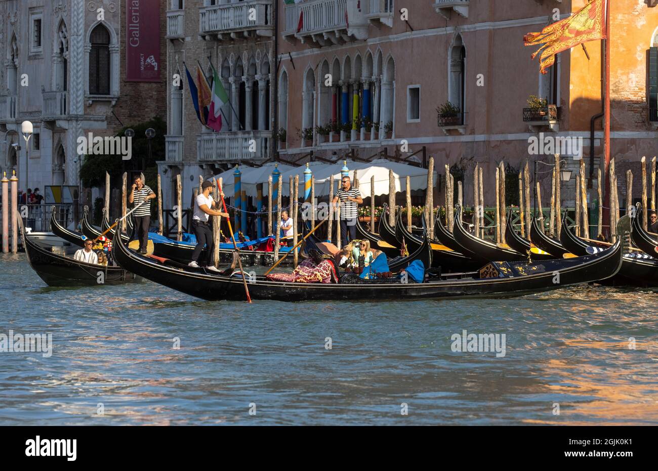 Una Gondola sul Canal Grande di Venezia che conduce alla laguna di San Marco. I turisti godono della splendida architettura di Venezia da una gondola. Foto Stock