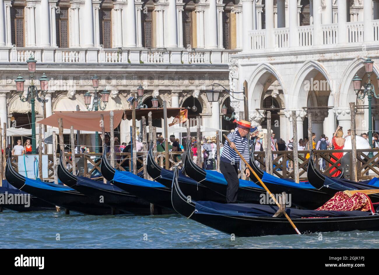 Una Gondola sul Canal Grande di Venezia che conduce alla laguna di San Marco. I turisti godono della splendida architettura di Venezia da una gondola. Foto Stock