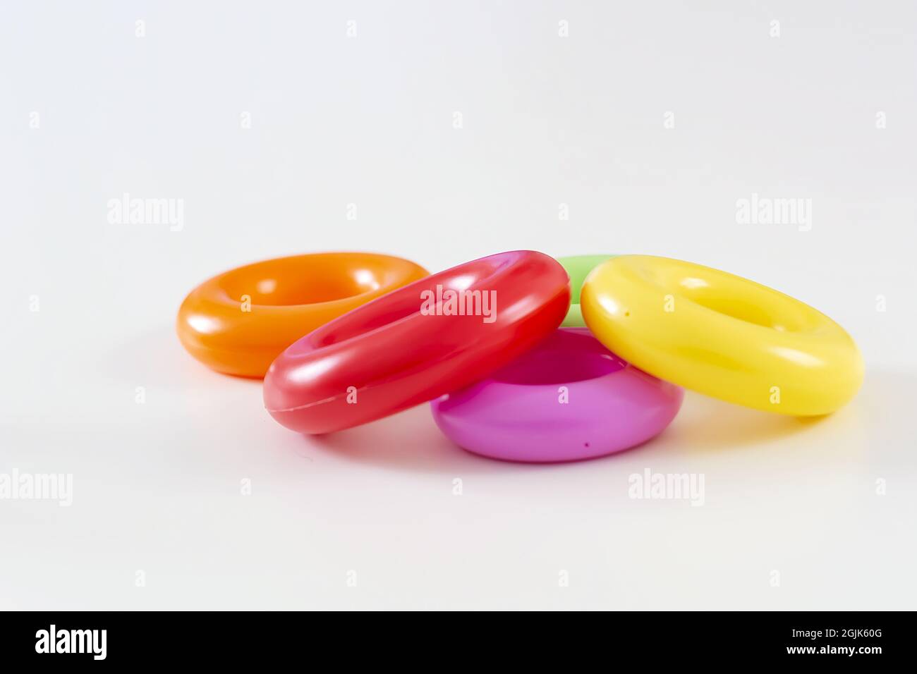 un gruppo di cinque colorati anelli di plastica isolati su uno sfondo bianco. Giocattoli per bambini. Stesse dimensioni per ciascun anello Foto Stock