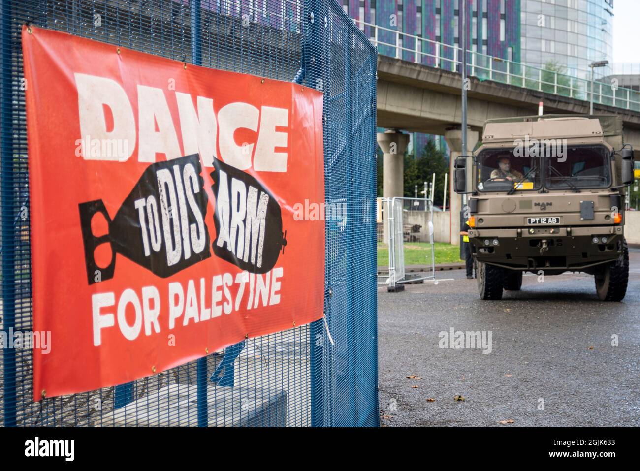 Disarmare per la Palestina segno di bandiera che protestano contro la fiera internazionale DSEI Defense & Security Equipment, con camion dell'esercito Foto Stock