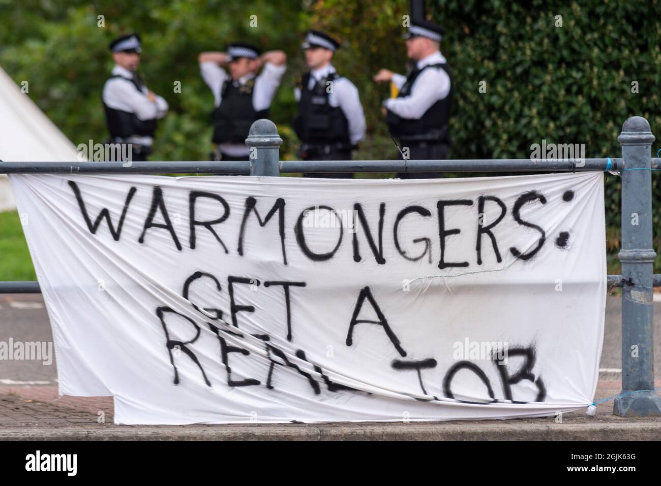 Segno di bandiera che protesta contro la fiera commerciale DSEI di Defense & Security Equipment International, Excel, Londra, Regno Unito. I guerrafondai firmano e la polizia Foto Stock