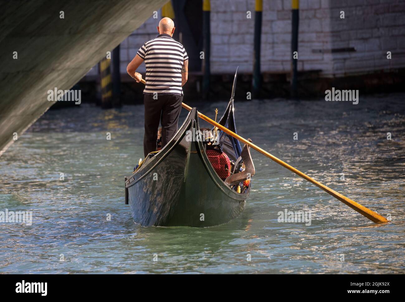 Una Gondola sul Canal Grande di Venezia che conduce alla laguna di San Marco. I turisti godono della splendida architettura di Venezia da una gondola. Foto Stock