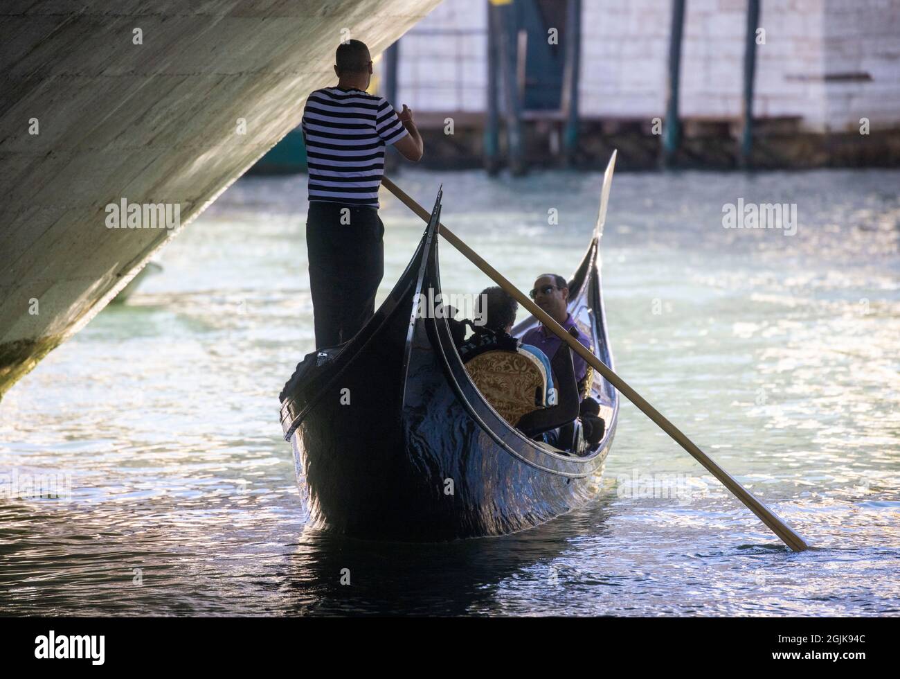 Una Gondola sul Canal Grande di Venezia che conduce alla laguna di San Marco. I turisti godono della splendida architettura di Venezia da una gondola. Foto Stock