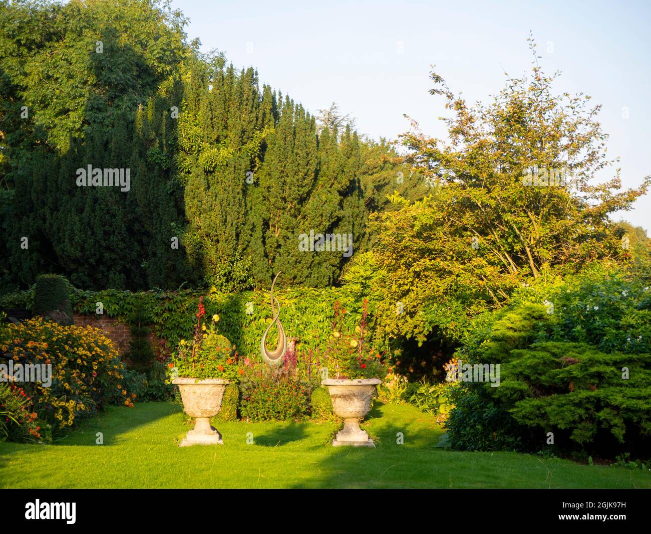 Ombra serale sul lato sud della Chenies Manor House. Dahlias a Chenies Manor, Buckinghamshire. Foto Stock