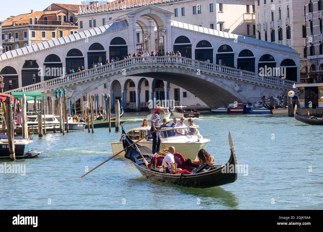 Una Gondola sul Canal Grande di Venezia che conduce alla laguna di San Marco. I turisti godono della splendida architettura di Venezia da una gondola. Foto Stock