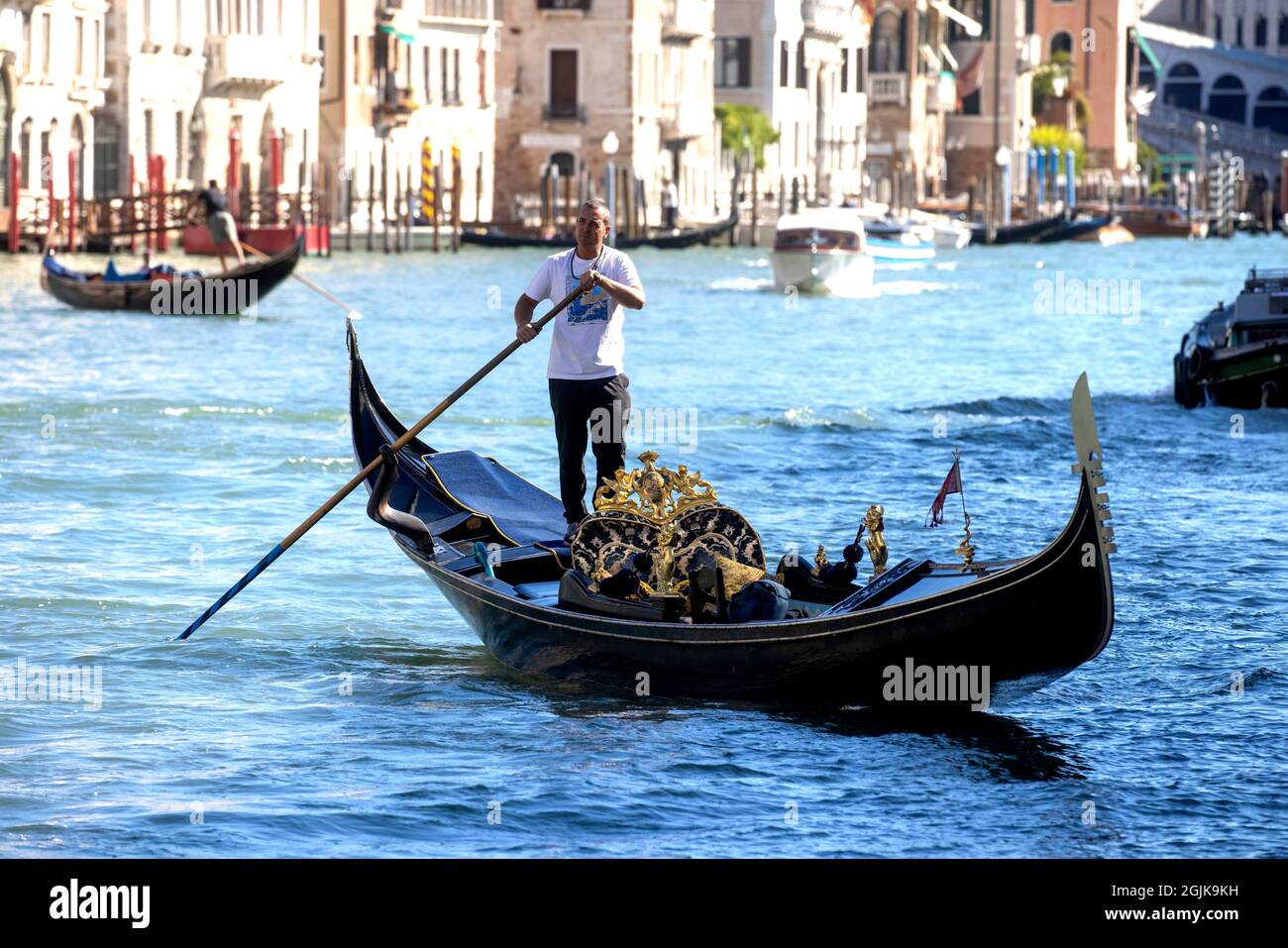 Una Gondola sul Canal Grande di Venezia che conduce alla laguna di San Marco. I turisti godono della splendida architettura di Venezia da una gondola. Foto Stock