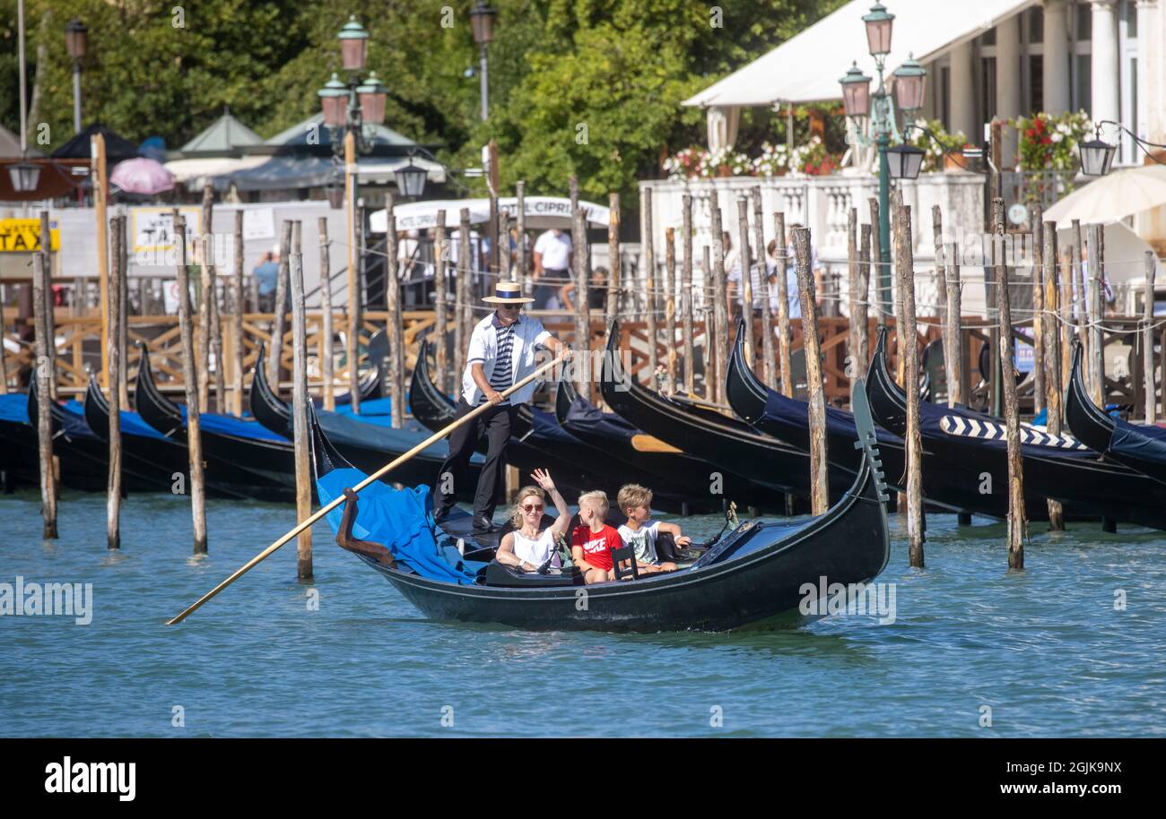 Una Gondola sul Canal Grande di Venezia che conduce alla laguna di San Marco. I turisti godono della splendida architettura di Venezia da una gondola. Foto Stock