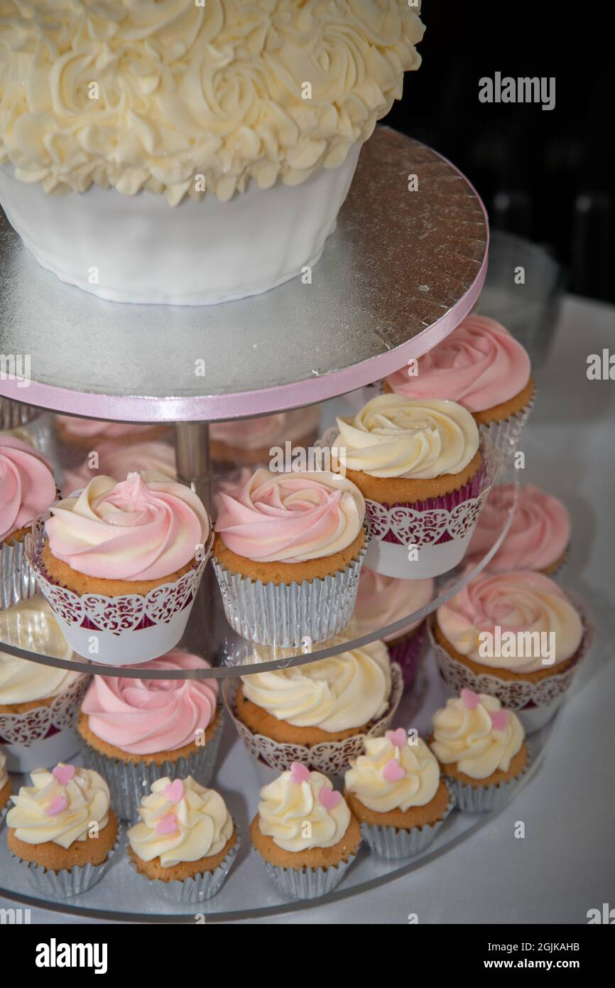 Cupcake su uno stand a forma di una grande torta per un ricevimento di nozze Foto Stock