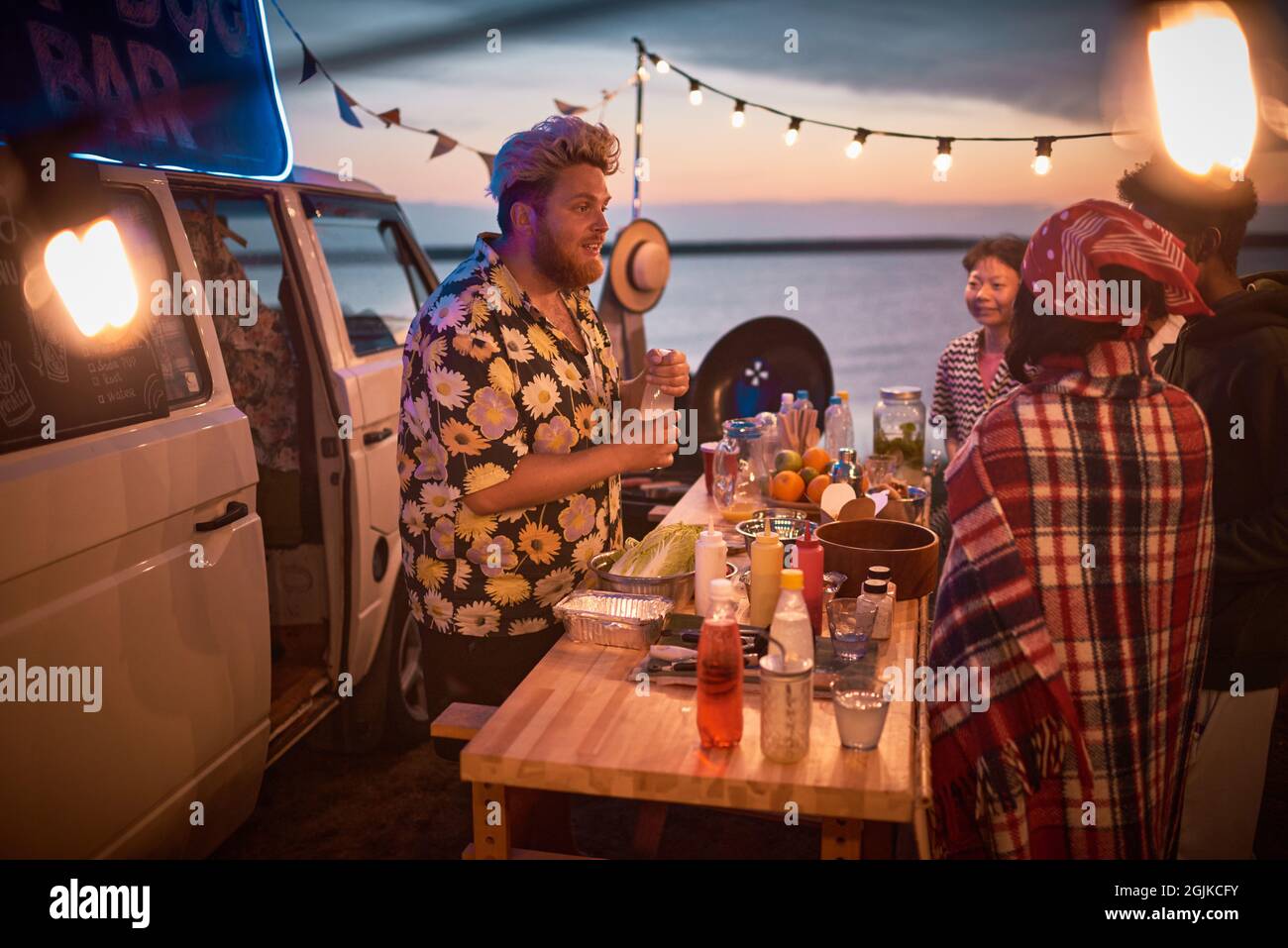 Giovane barman che fa cocktail alcolici per i giovani al Beach party Foto Stock
