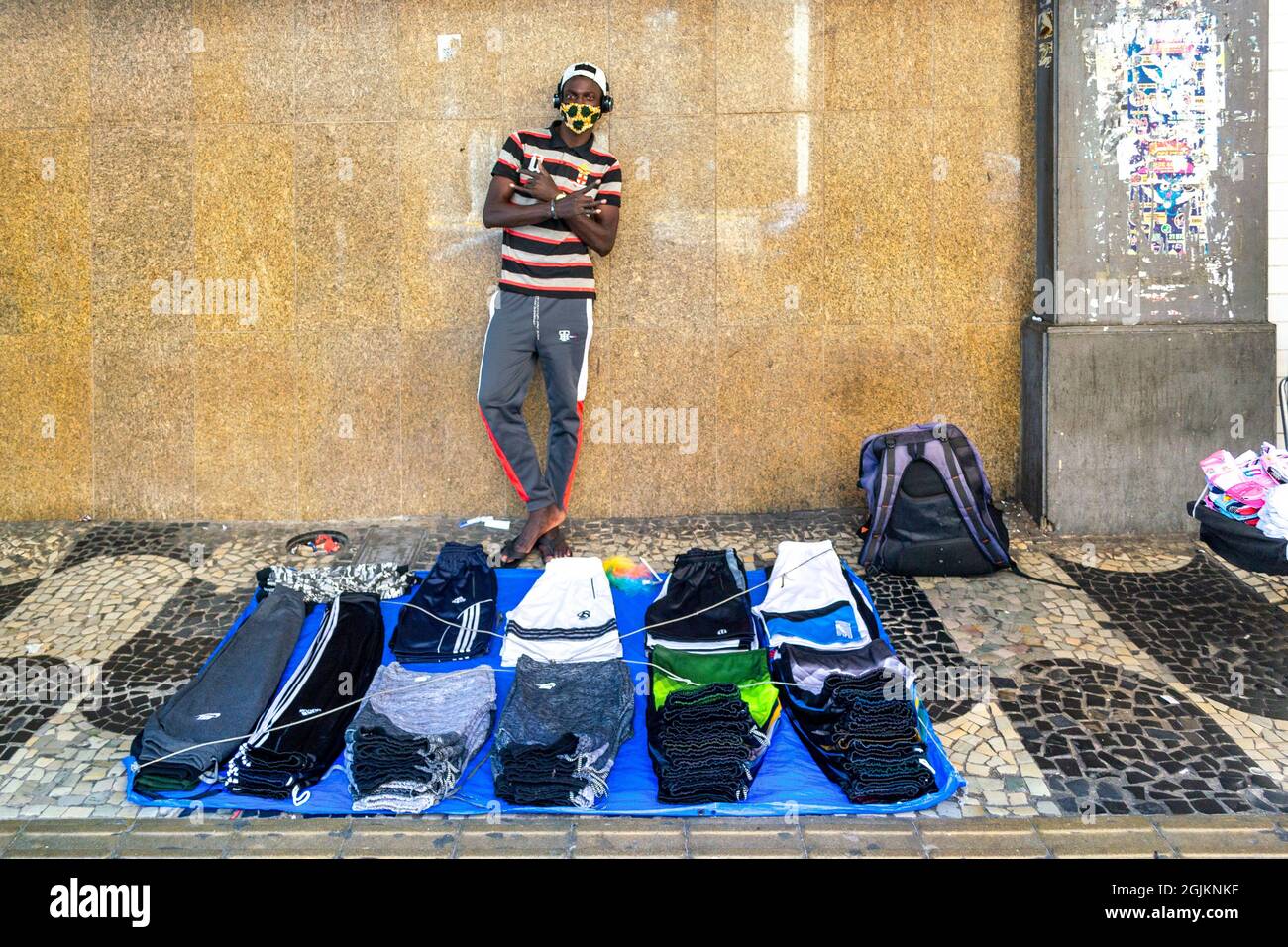 Giovane uomo brasiliano che vende merce di marca su una strada di Nitreoi, Rio de Janeiro, Brasile. Indossa una maschera protettiva per il viso. Foto Stock