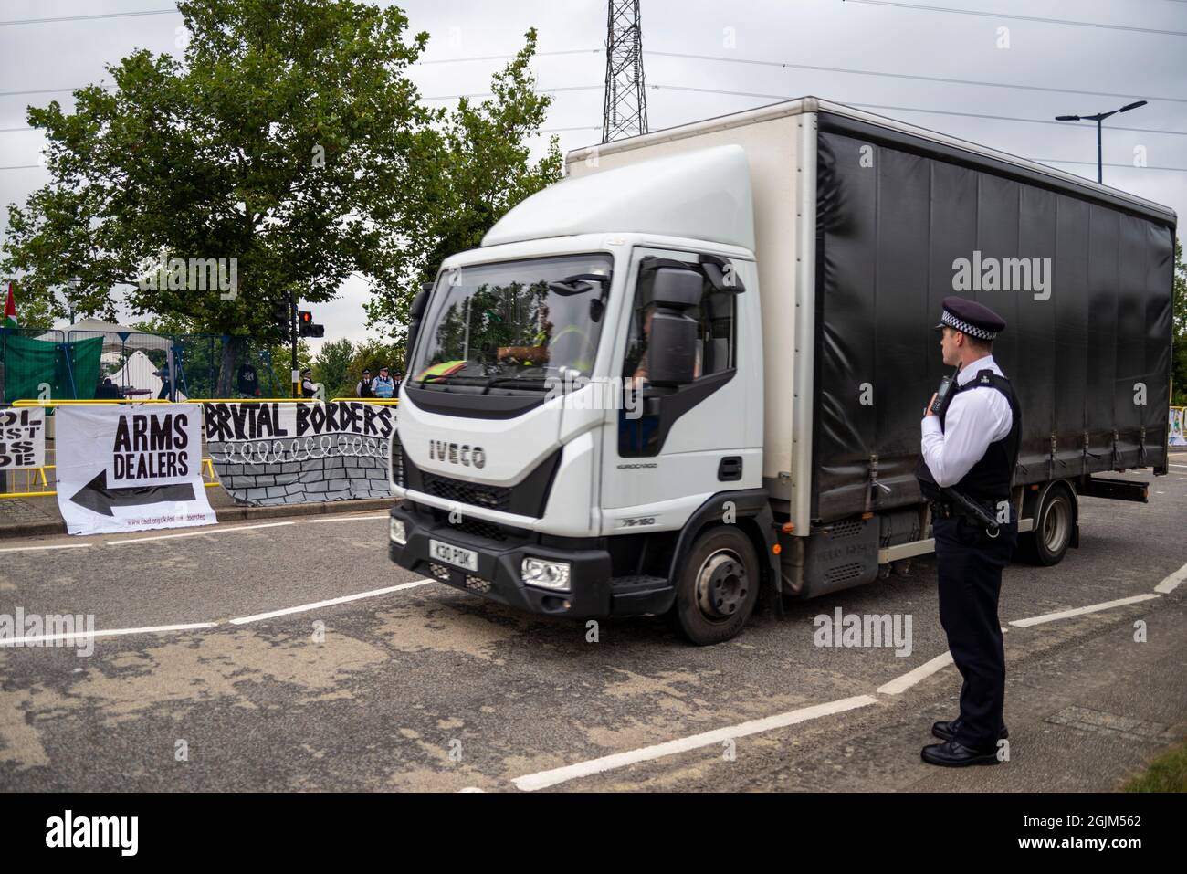 Cartello di passaggio camion che protesta contro la fiera DSEI Arms Fair Trade Show di Defense & Security Equipment International, Excel, Londra, Regno Unito. Polizia Foto Stock