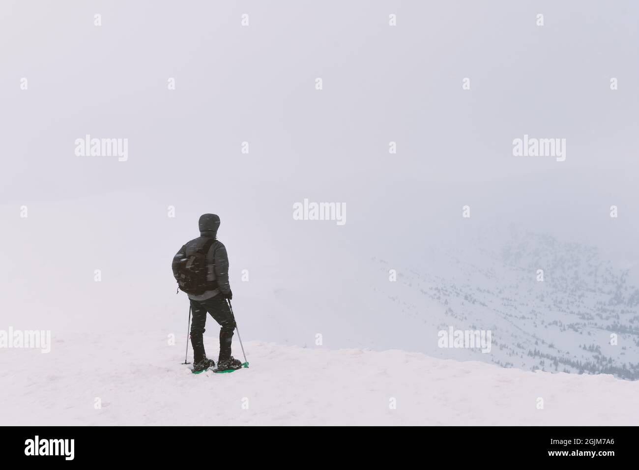 Da soli turistico con uno zaino in alta montagna in inverno. Concetto di viaggio Foto Stock