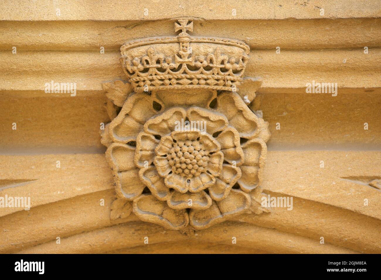 Scultura in pietra di una rosa Tudor e corona sopra una porta,Tom Quad, Christ Church College, University of Oxford, Oxford, Engerand, REGNO UNITO. Tudor doppia rosa incoronata royale. Foto Stock