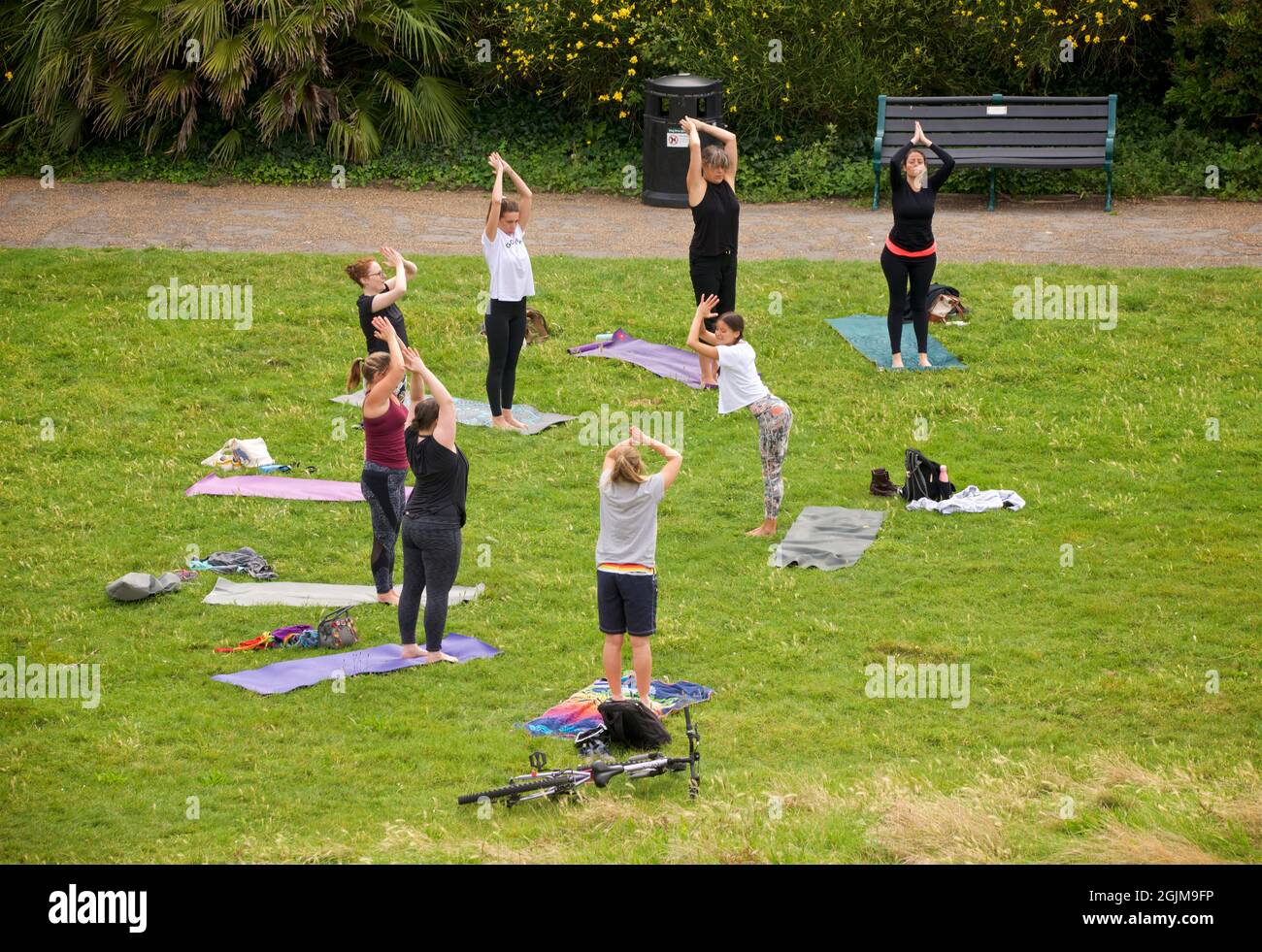 Lezione di yoga tenuto sull'erba in Brunswick Square Garden, Hove, Brighton & Hove, East Sussex, Enghand, REGNO UNITO. Foto Stock