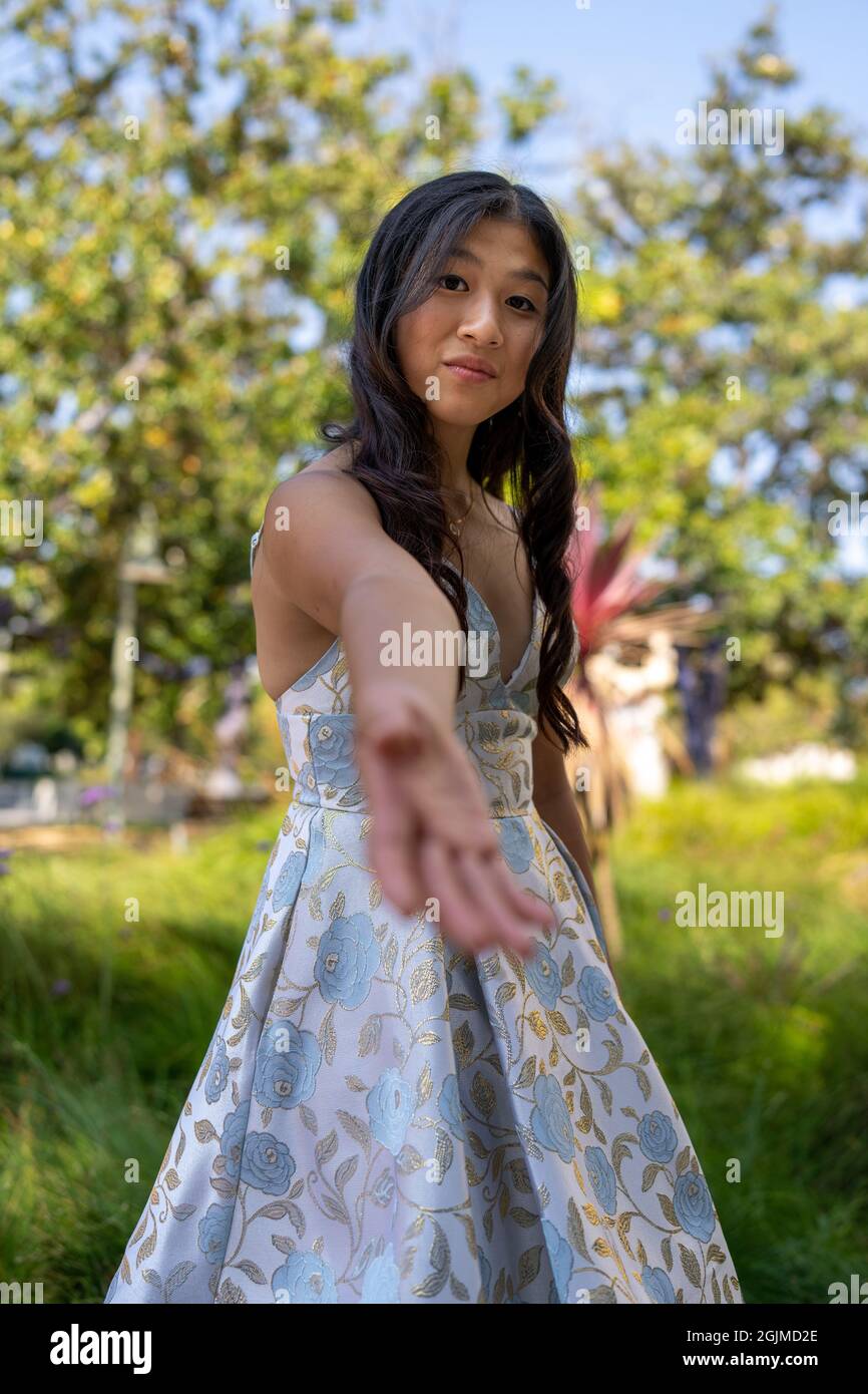 Ragazza asiatica adolescente che raggiunge le mani d'aiuto Foto Stock